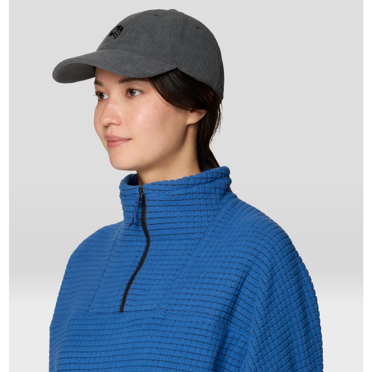 Dark gray corduroy baseball cap with logo, worn on model, side angle view
