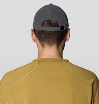 Back view of a dark gray corduroy dad cap with adjustable strap, worn on model