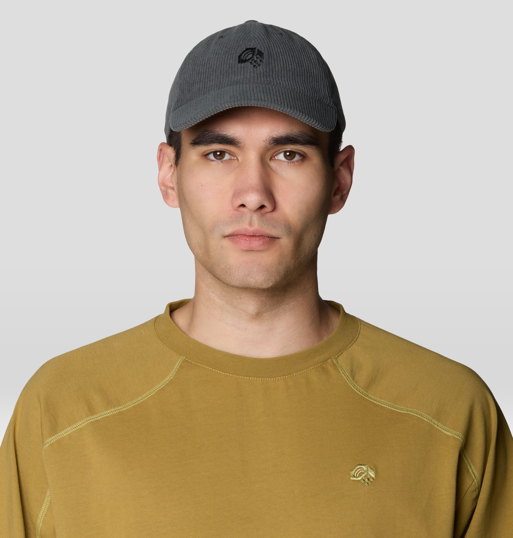 Dark gray corduroy dad cap with embroidered logo, worn on male model, front view