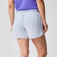 Light blue women's running shorts with elastic waistband, rear view showing relaxed fit