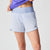 Women's light blue running shorts with wide waistband, zip pocket, and split hem, front view