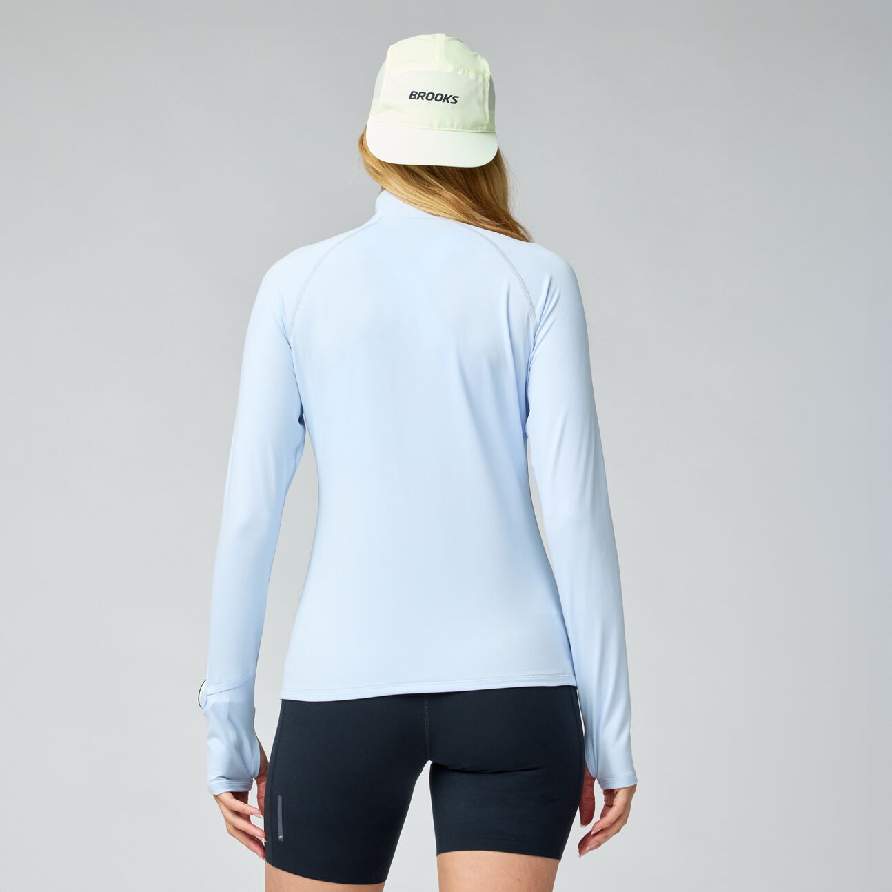 Light blue long-sleeve athletic shirt with half zip, shown from back view