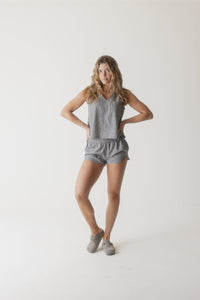 Gray ribbed sleeveless top and matching shorts set worn by woman on white background
