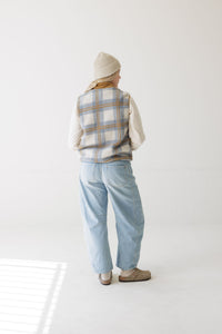 Women's plaid fleece vest, back view, worn over cream long-sleeve with light wash jeans