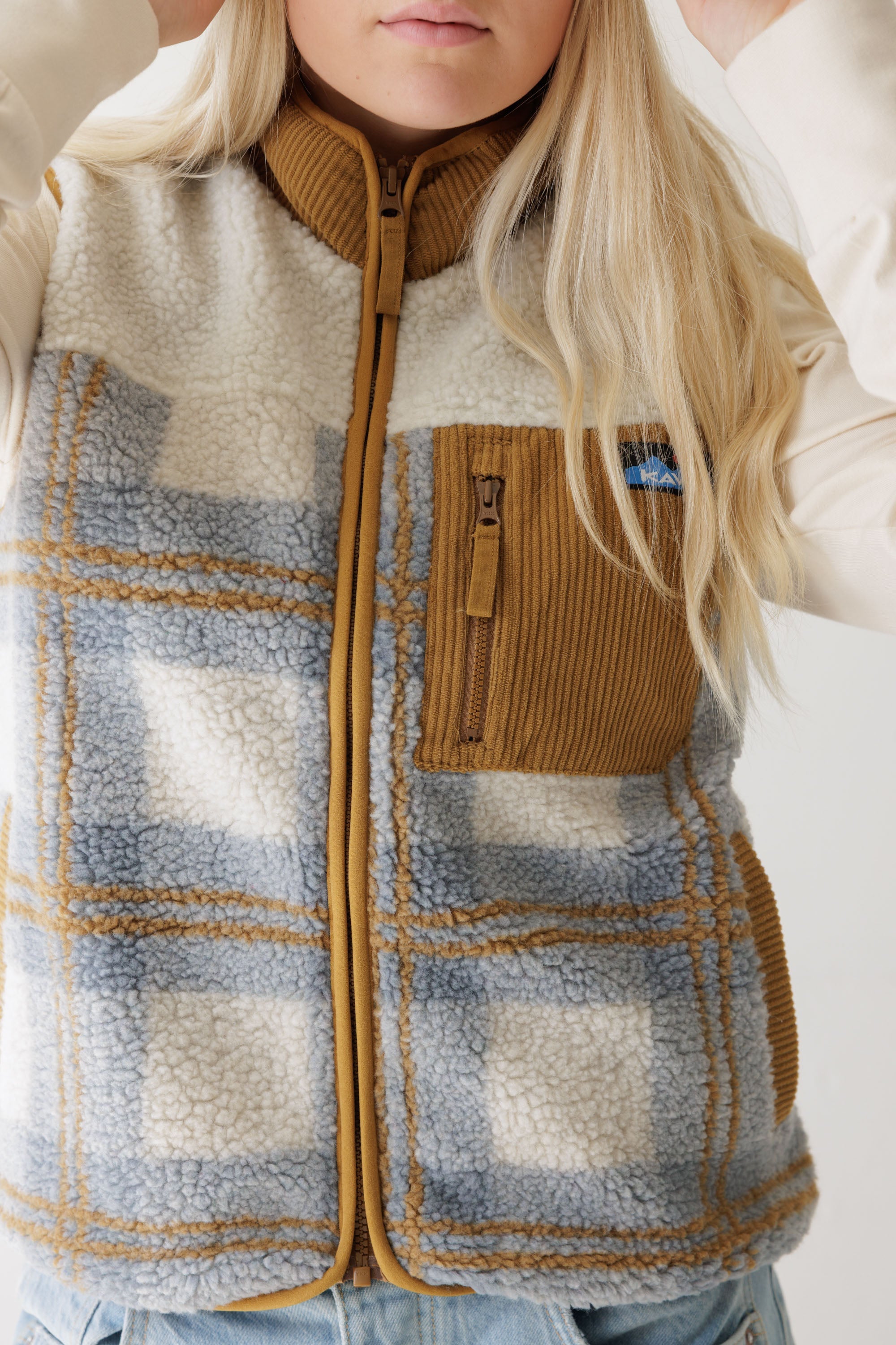 Women's sherpa fleece vest with plaid pattern, zip chest pocket, and corduroy trim, front detail view
