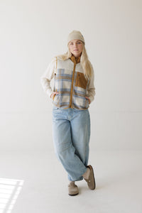 Women's sherpa fleece vest with plaid pattern, full zip, chest pocket, worn over cream long-sleeve