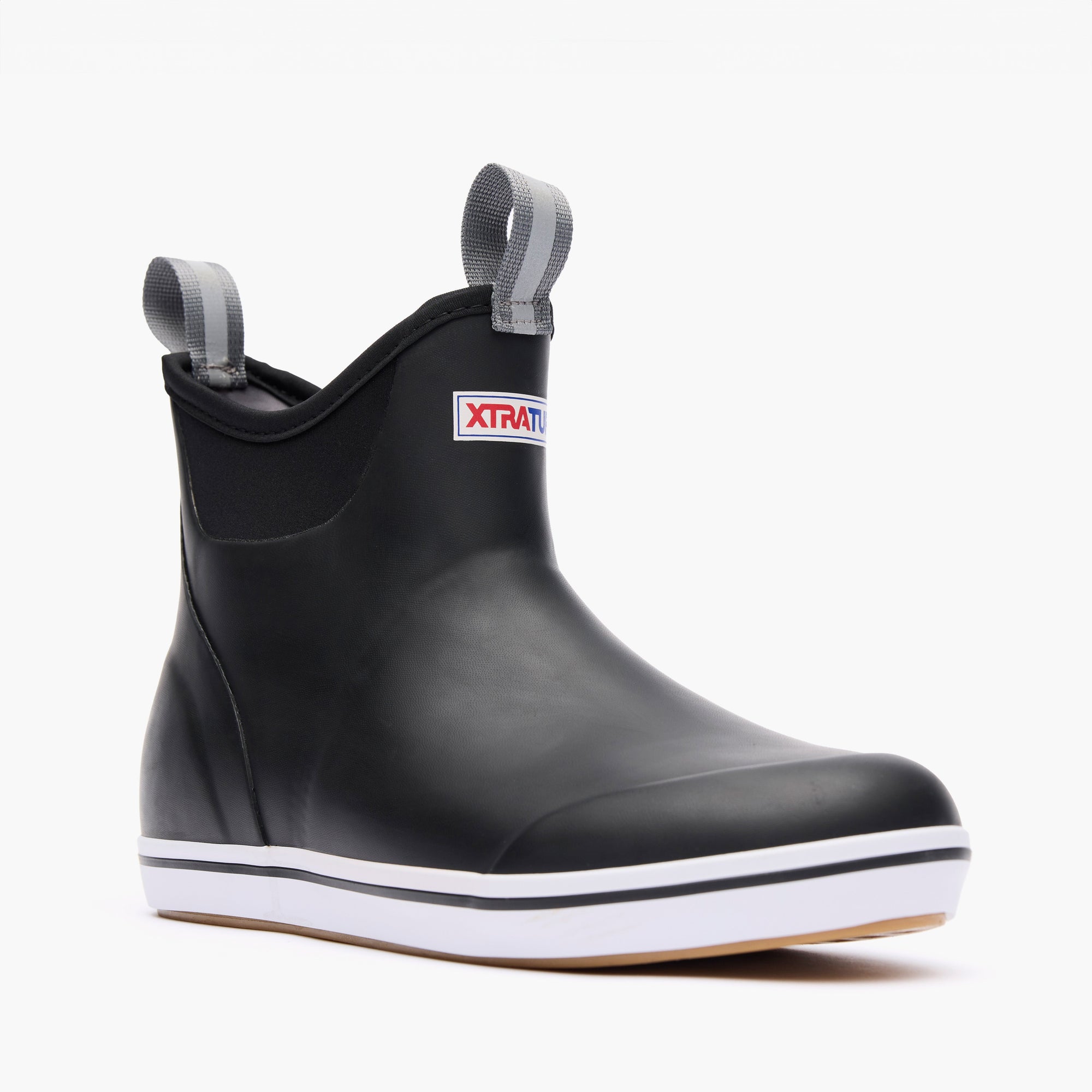 Black rubber ankle deck boot with pull tabs, elastic side panels, and white sole, three-quarter view