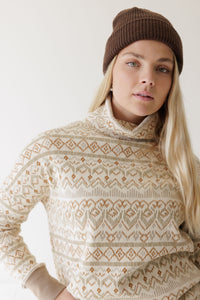 Women's turtleneck pullover sweater with Fair Isle geometric pattern, worn with brown beanie hat