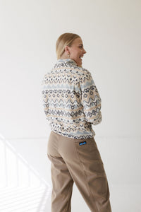 Women's patterned fleece pullover with geometric design, back view on model, with khaki pants