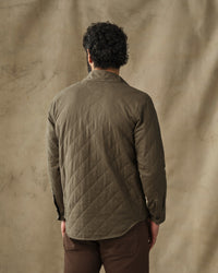 Back view of men's quilted olive green shirt jacket with diamond stitching pattern