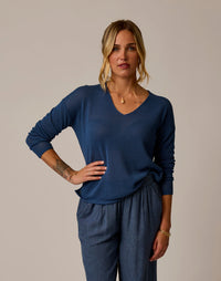 Woman wearing blue textured mesh pullover with v-neck and long sleeves
