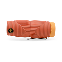 Compact monocular with textured terracotta body, spiral grip pattern, and orange eyepiece cap
