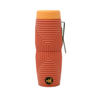 Compact monocular with ribbed terracotta silicone sleeve, orange cap, and metal clip, front view