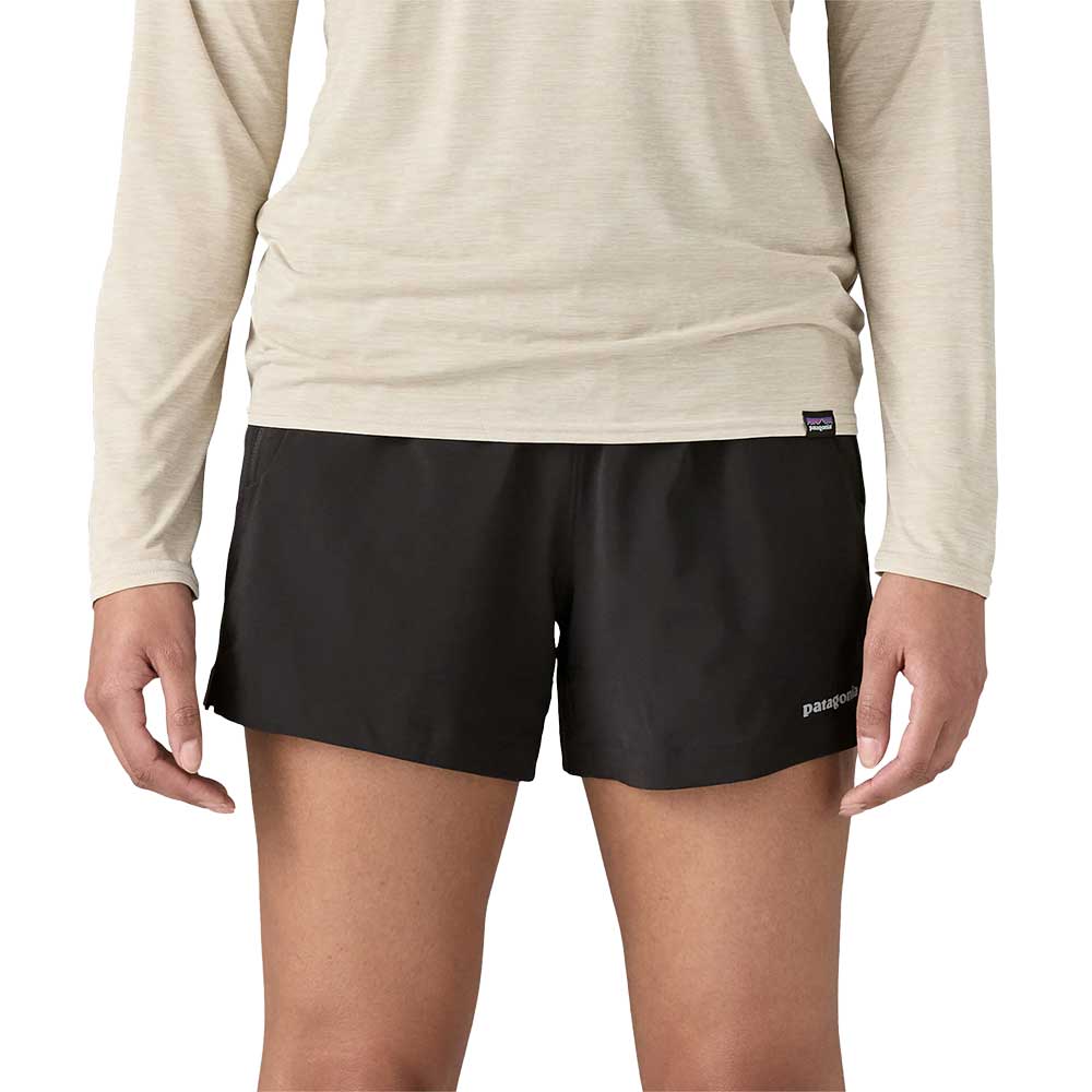 Black athletic shorts with side panels worn with beige long-sleeve top