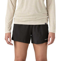 Black athletic shorts with side panels worn with beige long-sleeve top