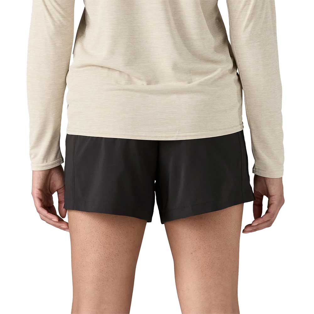 Black athletic shorts worn with beige long-sleeve top, back view showing fit and length
