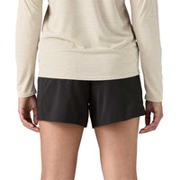 Black athletic shorts worn with beige long-sleeve top, back view showing fit and length