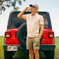 Men's short-sleeve snap button shirt with floral print, worn on model outdoors near red Jeep