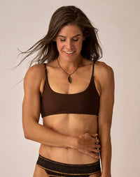 Women's brown reversible bikini top with adjustable patterned straps, front view on model