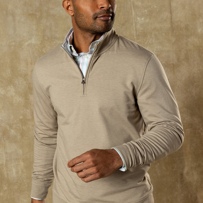 Man wearing light tan quarter-zip pullover over striped shirt, three-quarter view