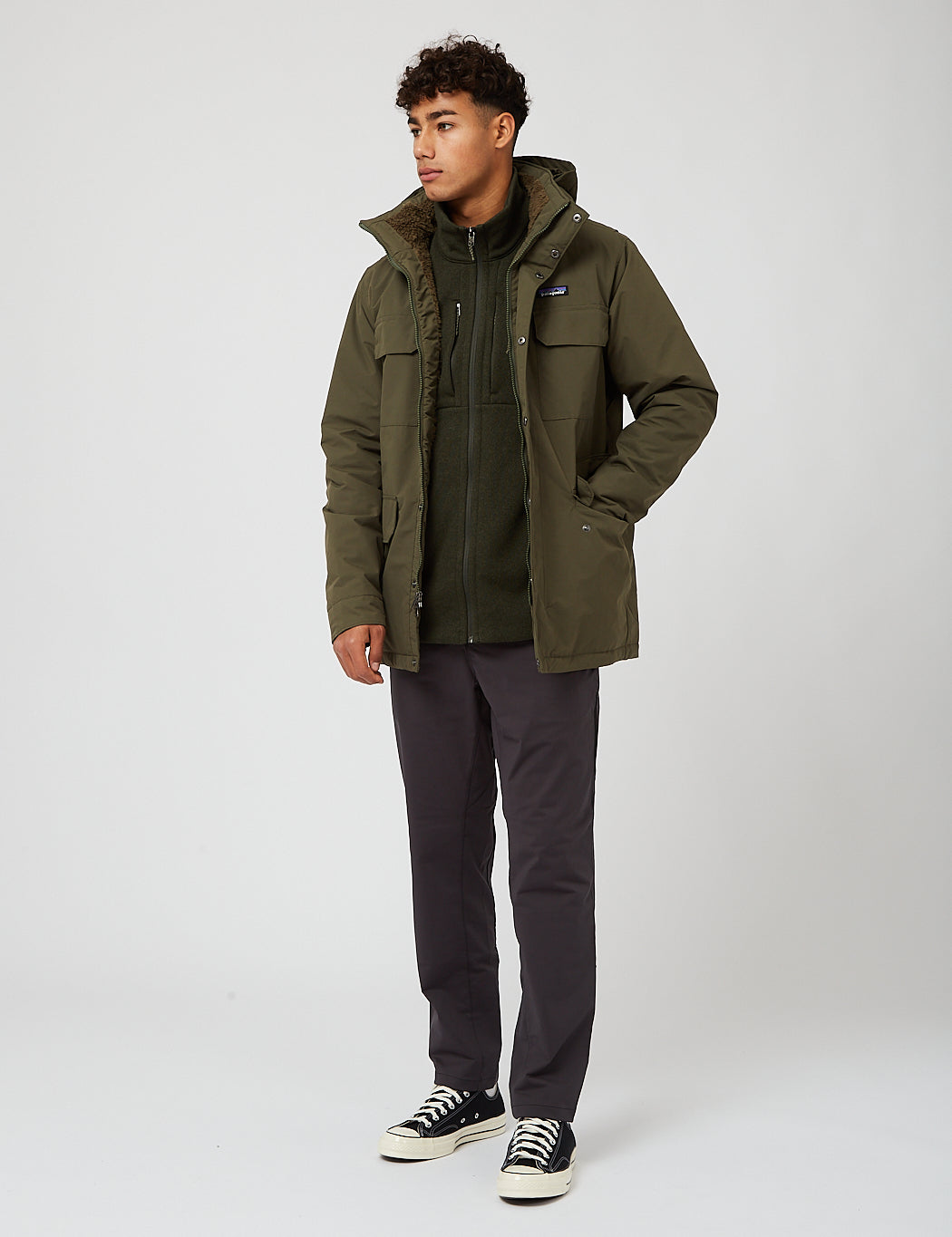 Men's olive green parka jacket with hood, chest pockets, and fleece lining, full-length front view