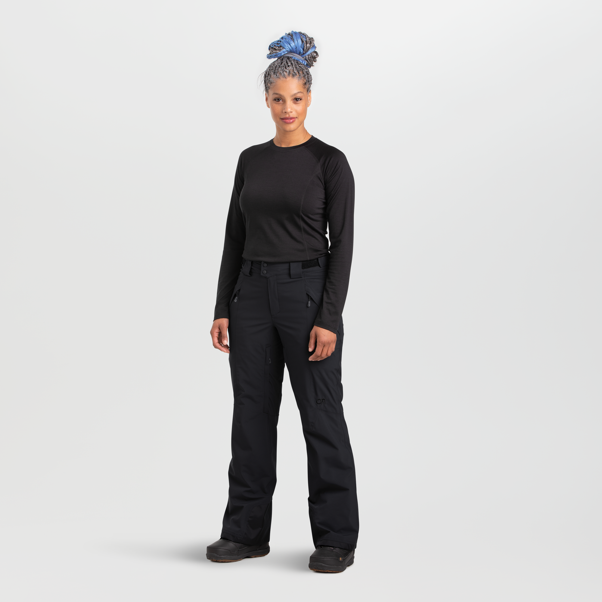 Women's black snow pants with multiple pockets, front view, paired with black base layer top