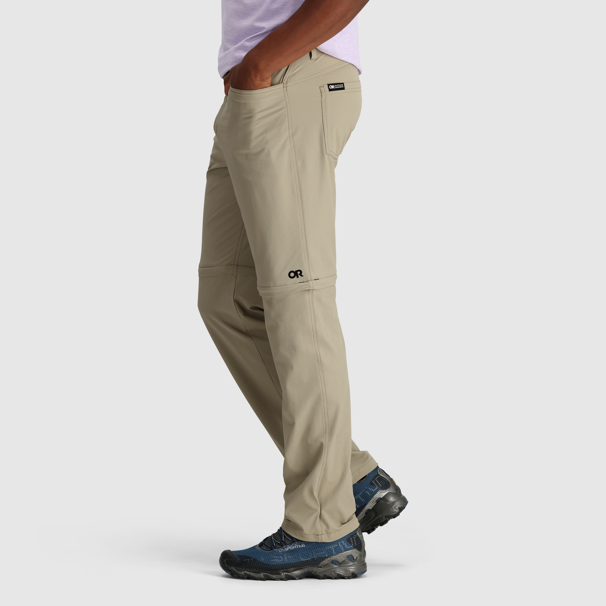 Khaki convertible hiking pants with zip-off legs, side profile view showing outdoor features