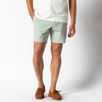 Light green chino shorts worn with white t-shirt and brown boat shoes
