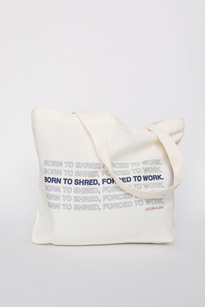 Natural canvas tote bag with repeated 'Born to Shred, Forced to Work' text print, front view