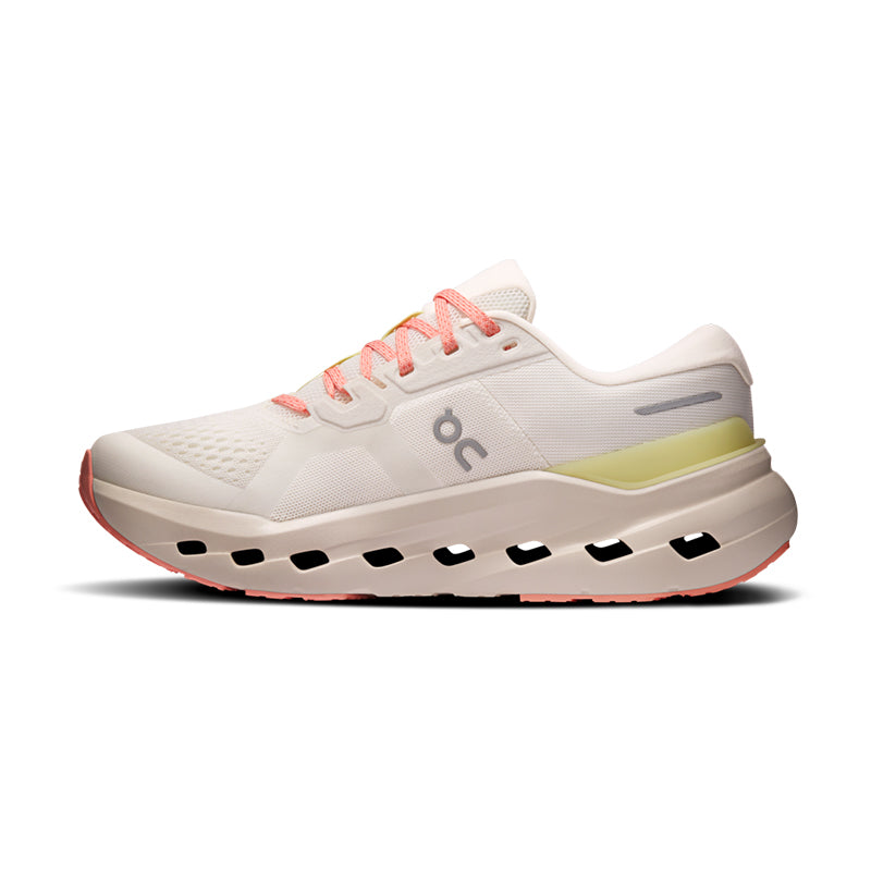 Women's running shoe in off-white with coral laces, yellow heel accent, and chunky cushioned sole, lateral view