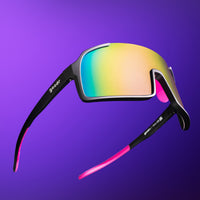 Sport sunglasses with black frame, rainbow reflective lenses, and pink temple accents on purple background