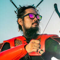 Black sunglasses with purple mirrored lenses worn by bearded man in orange life vest