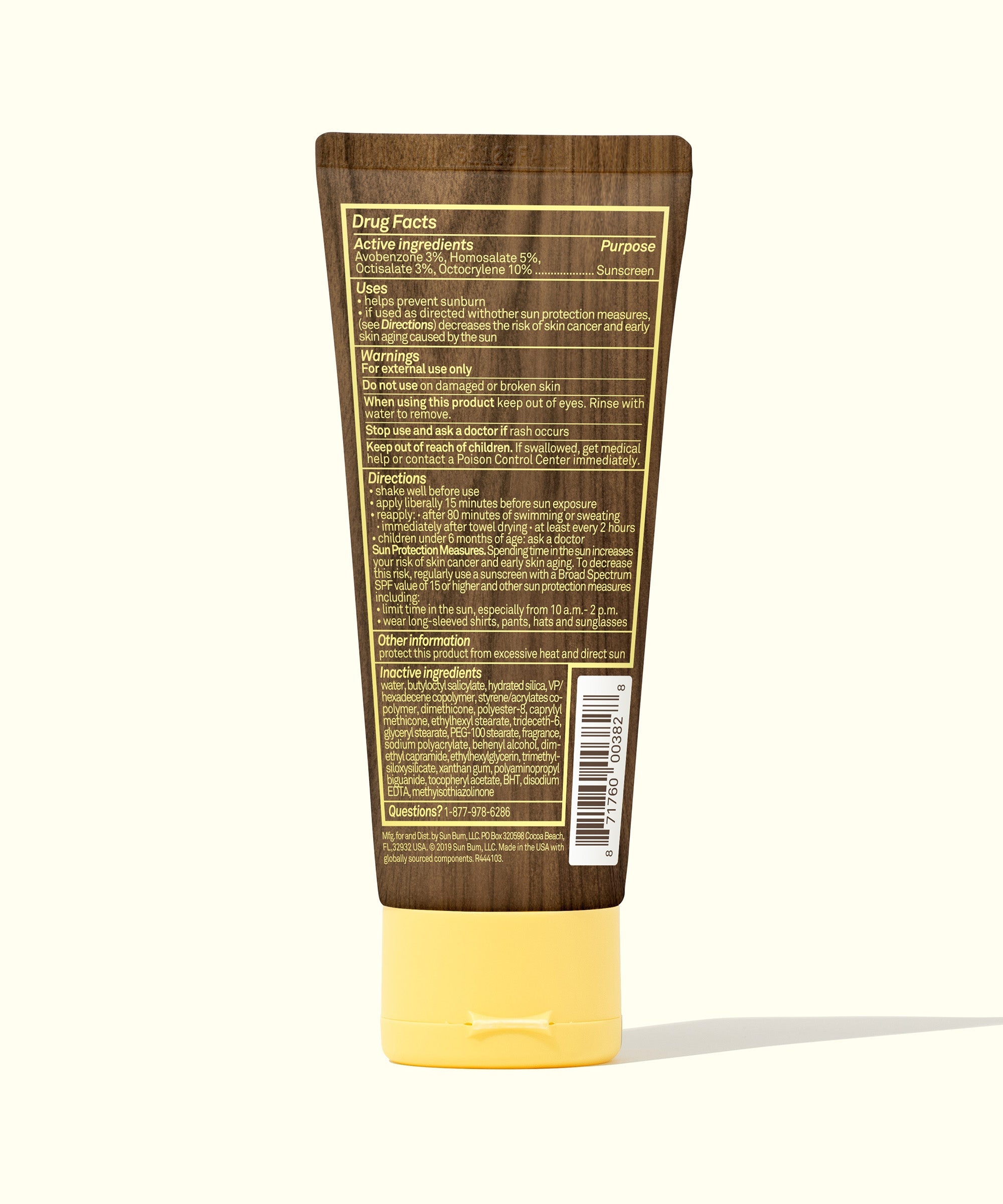 Sunscreen lotion tube with brown packaging and yellow cap, back panel showing ingredients