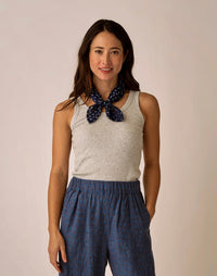 Light grey ribbed sleeveless tank top worn with blue patterned pants and neck scarf