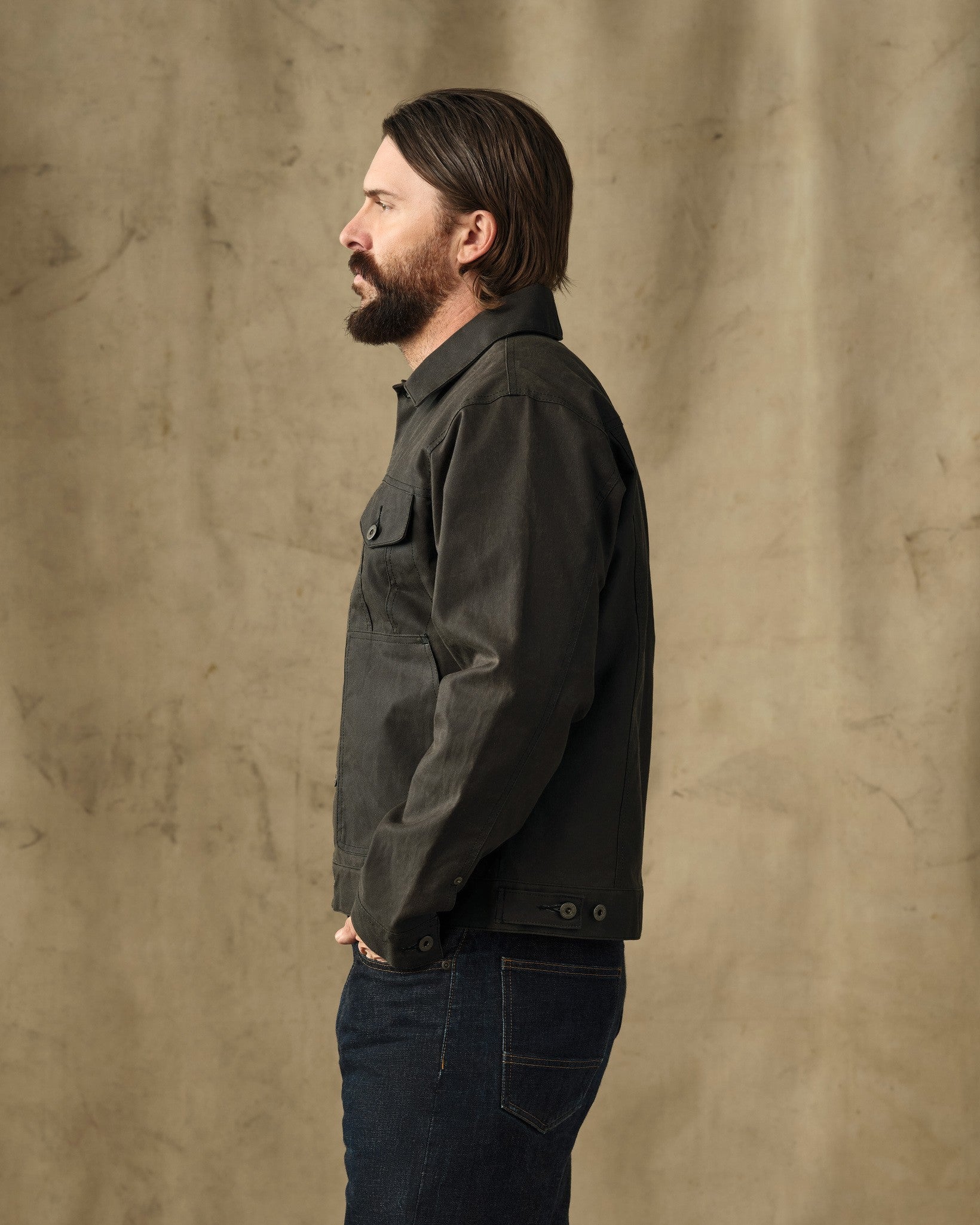 Men's short work jacket in dark charcoal, side profile view, with chest pockets and button closure