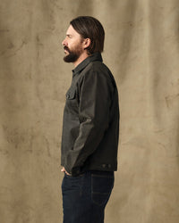 Men's short work jacket in dark charcoal, side profile view, with chest pockets and button closure