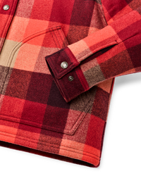 Close-up detail of plaid insulated jacket sleeve cuff with silver snap buttons