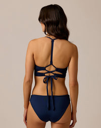 Navy blue bikini bottom with full coverage cut, back view on model
