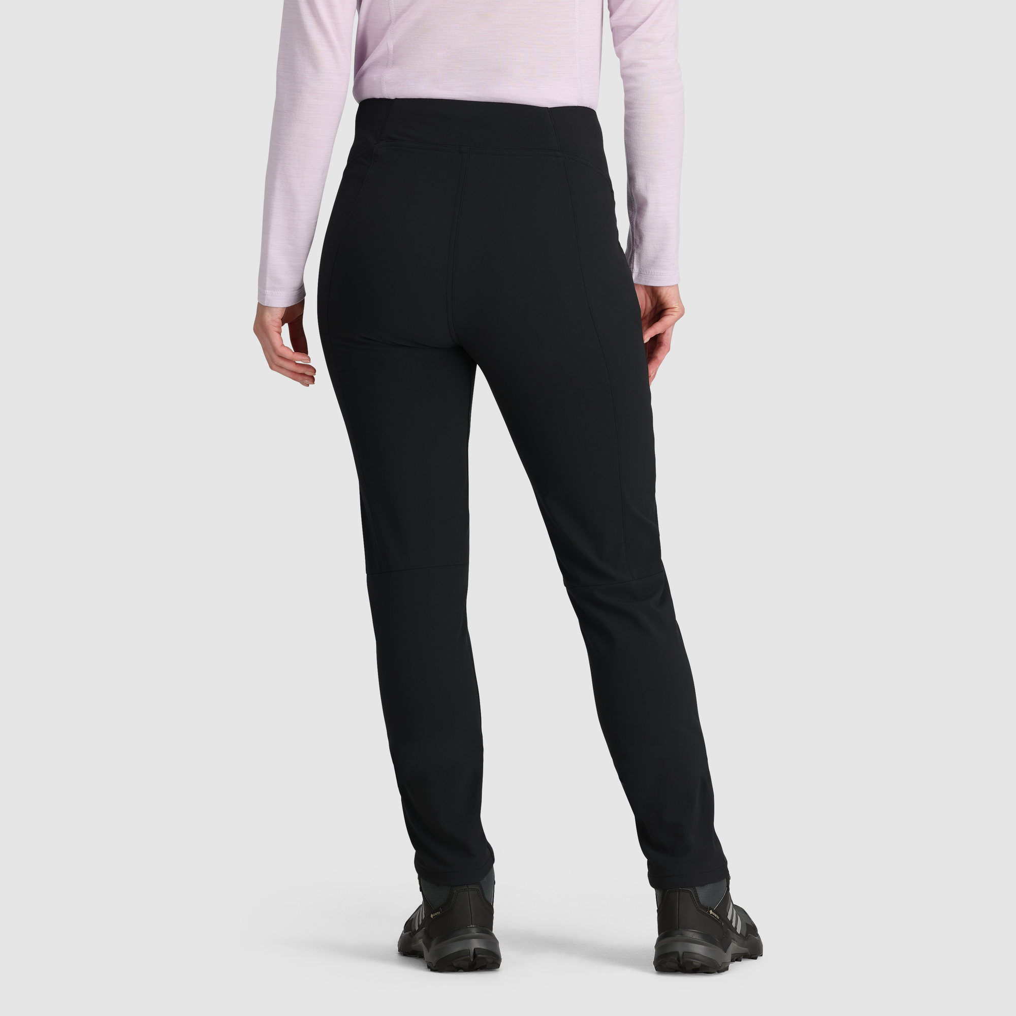 Women's slim-fit fleece-lined pants in black, back view, shown with hiking shoes