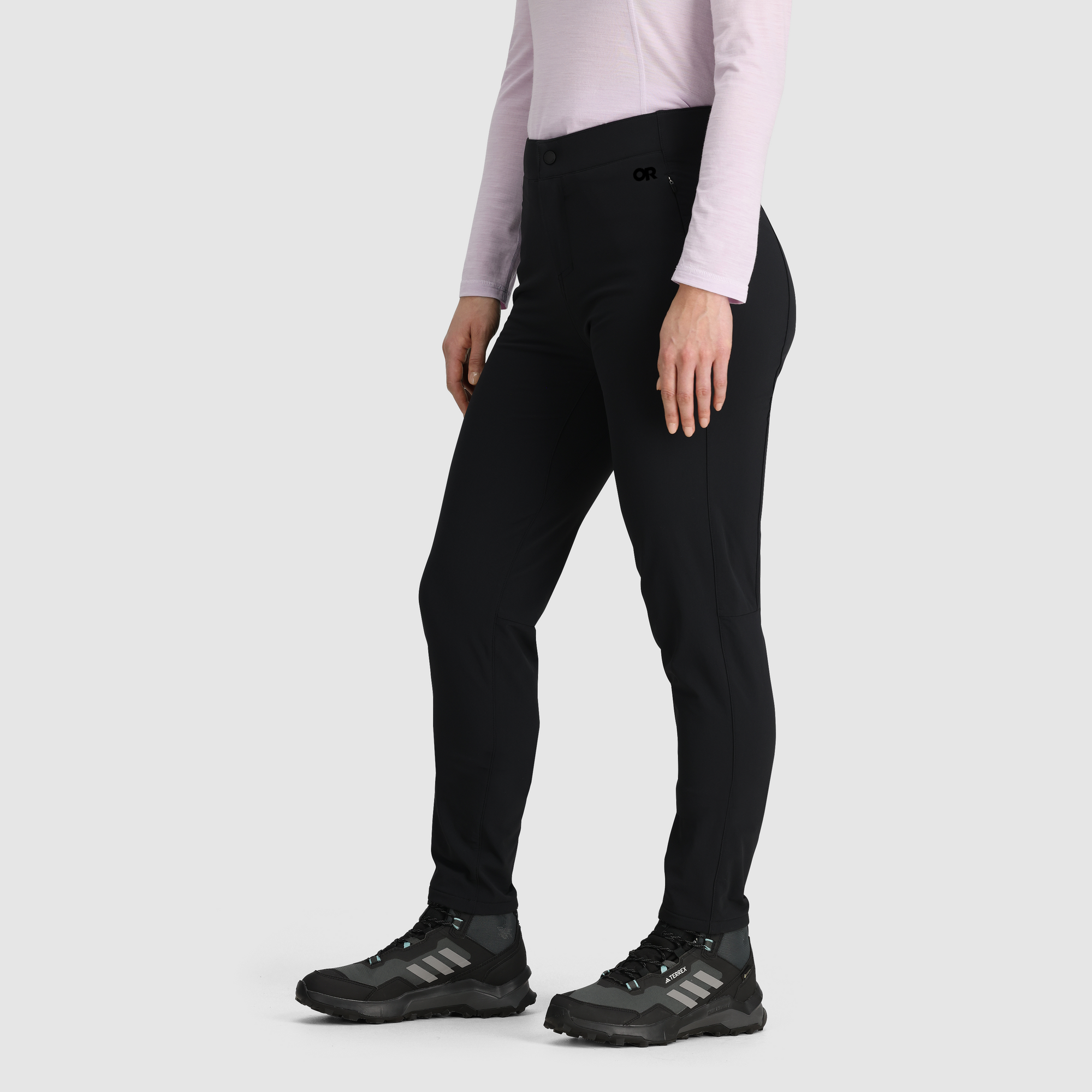 Black slim-fit fleece-lined pants on model, side view, with trail running shoes