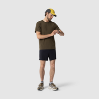 Man wearing dark olive green t-shirt and black shorts checking his watch