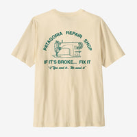 Cream colored t-shirt with repair shop graphic and sewing machine illustration on back