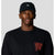 Black baseball cap with small logo on front worn by model