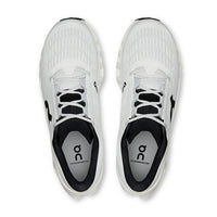 Light colored athletic running shoes with mesh upper and black laces, top-down view