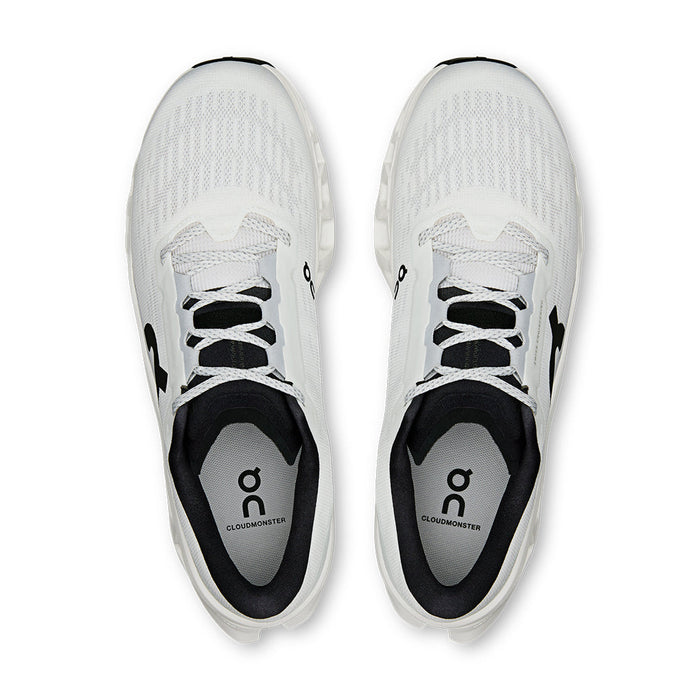 Light colored athletic running shoes with mesh upper and black laces, top-down view