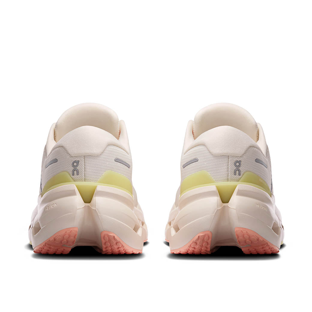 Light colored running shoes shown from rear view with textured outsole and yellow accent details