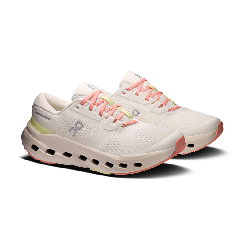 Pair of women's running shoes in off-white with coral laces and chunky CloudTec sole, three-quarter view