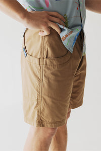 Tan cargo shorts with multiple pockets shown from side angle on model