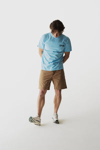 Tan colored casual shorts worn by model in studio setting, front view