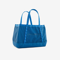 Bright blue tote bag with dual handles and front pocket on clean background